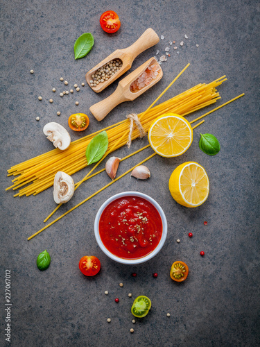 The thin spaghetti on dark stone background. Yellow italian pasta with ingredients. Italian food and menu concept.