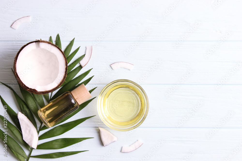coconut oil, coconuts and green tropical leaves on wooden background. Top view. coconut oil, coconuts and green tropical leaves on wooden background. Top view.