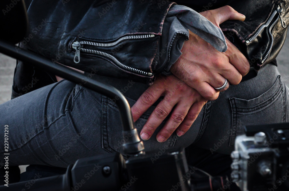 hands of a biker man hugging a biker woman's back sitting on a motorcycle hands of a biker man hugging a biker woman's back sitting on a motorcycle