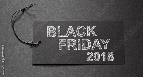 Black Friday 2018 text on a black tag on black paper background