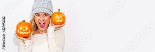 Young woman holding pumpkins on a white background