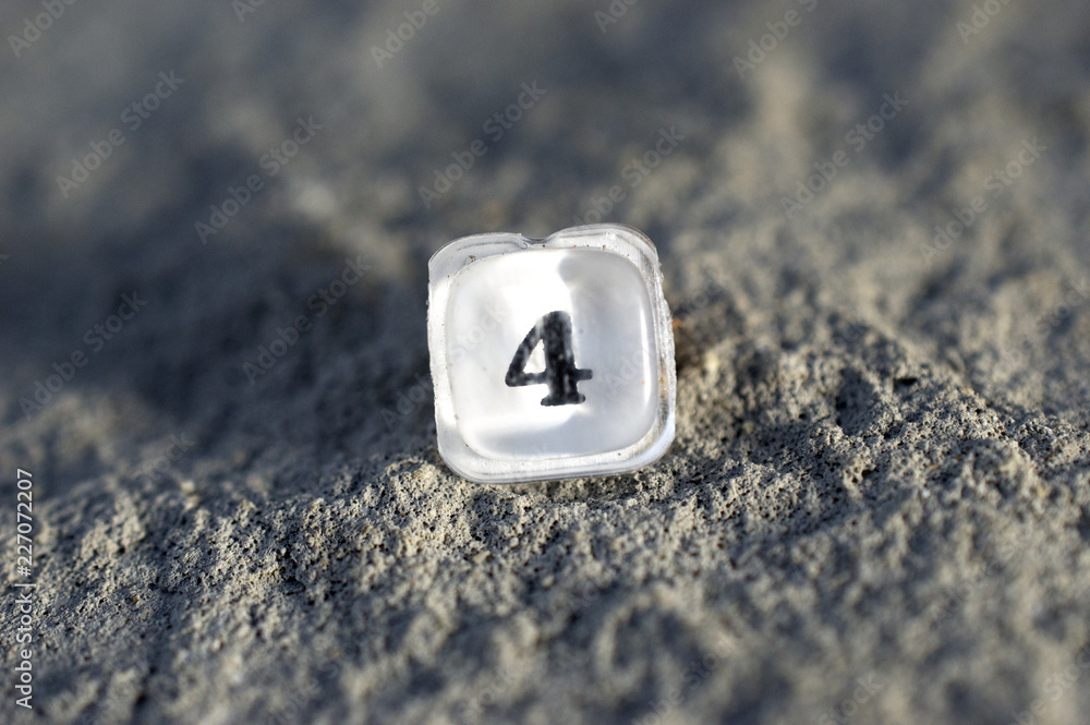 plastic translucent button number 4 from an old calculator on a concrete background,shallow dof plastic translucent button number 4 from an old calculator on a concrete background,shallow dof
