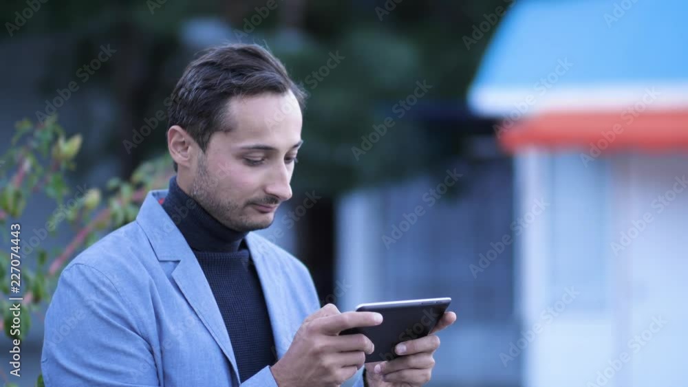 unshaven man dressed in business style uses a tablet unshaven man dressed in business style uses a tablet