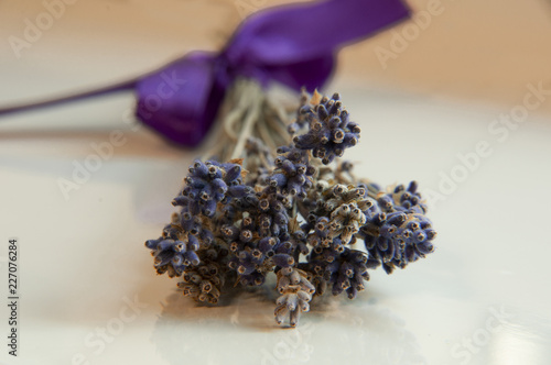 lavender bouquet whit purple ribbon lying on a white table