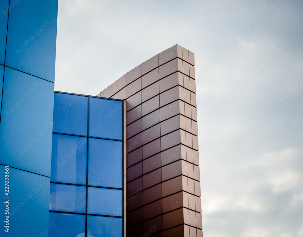 fragment of a building wall with windows on a background of autumn sky