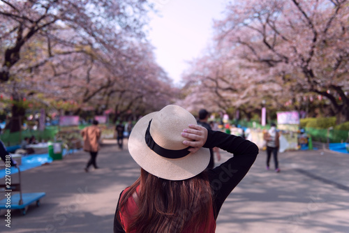 Foto Woman is traveling inside Ueno Park during Hanami Spring festival in Tokyo, Japan