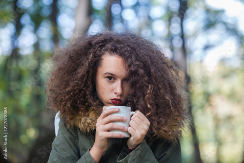 Curly hair teen girl holdin...