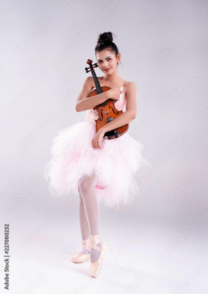 The beauty is wearing ballet dress and satin ballet violin with arms,paoint straight up,prepare for | Adobe Stock