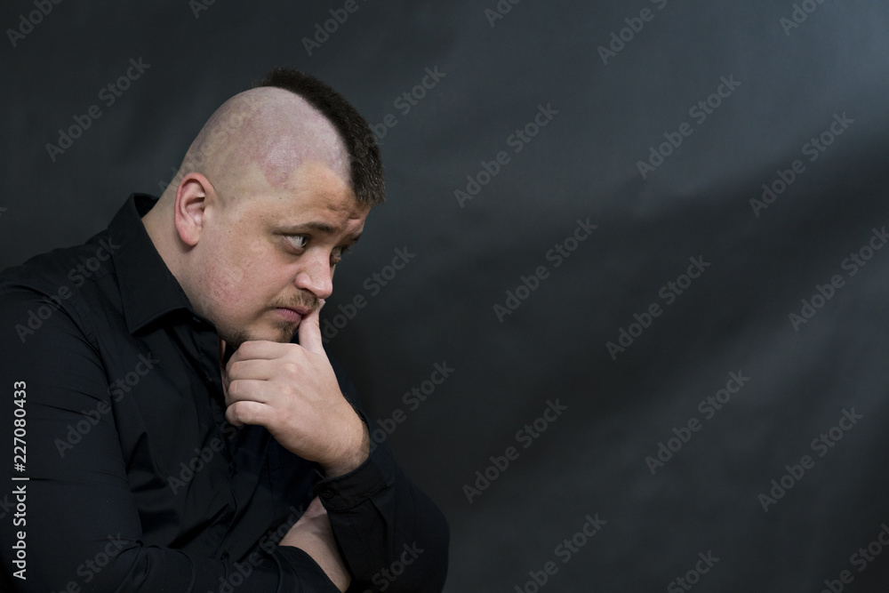 Punk. The hand is pressed to the head. Pensive face expression. Looking for a way out of this situation. copy space Punk. The hand is pressed to the head. Pensive face expression. Looking for a way out of this situation. copy space