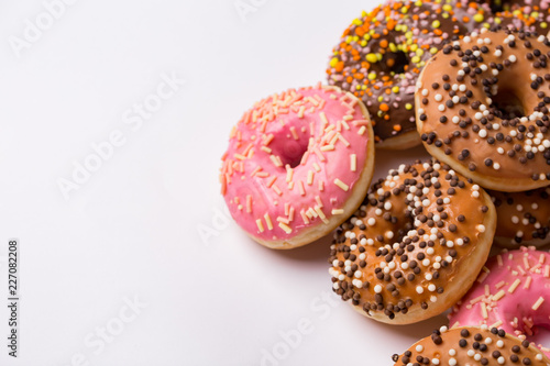 Donuts glazed with sprinkles on a light background