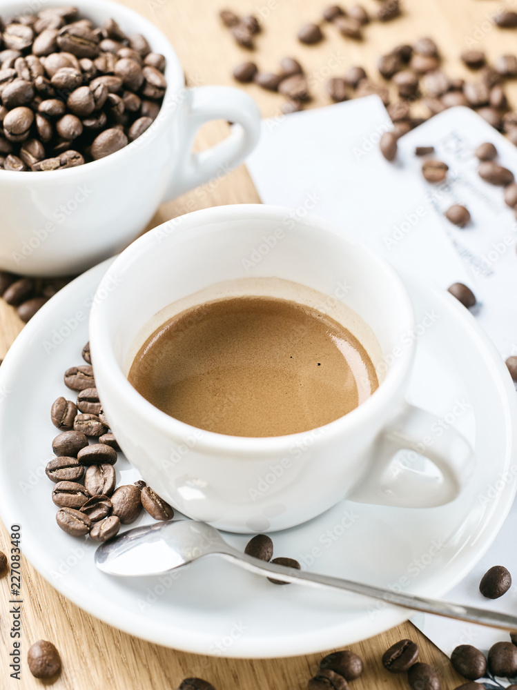 Obraz premium Cup of coffee full of coffee beans.