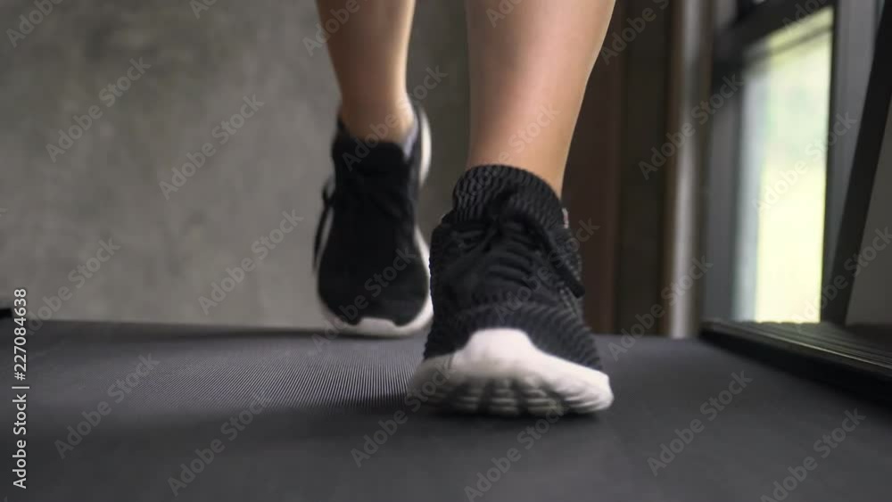 Young Woman Jogging on Treadmill at Gym. Front Close Up View