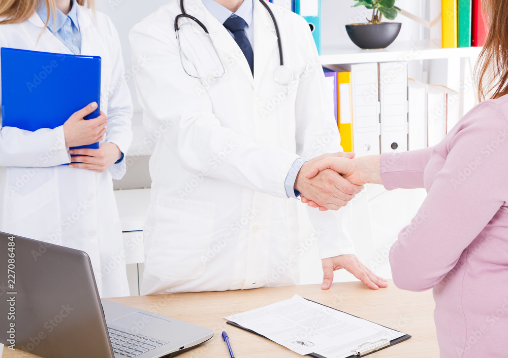 doctor shakes the female hand his patient in clinic, medical office. Healthcare concept, health insurance doctor shakes the female hand his patient in clinic, medical office. Healthcare concept, health insurance