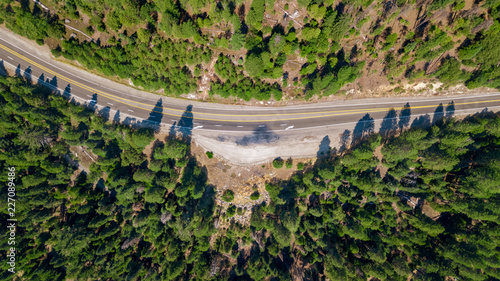 Drone view of the road crossing the wood uphill the valley going to lake Tahoe