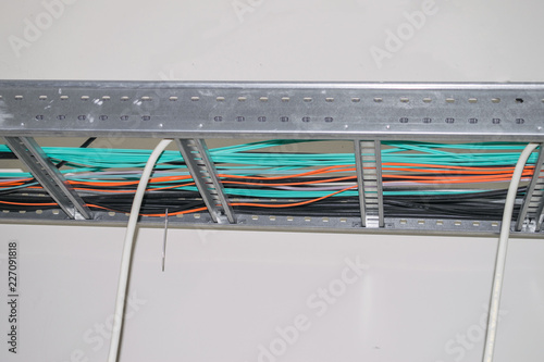 Electrical and fiber optic Internet wires are laid along the metal frame of the suspended ceiling. Multicolored cables for electrical and telecommunications wiring photo