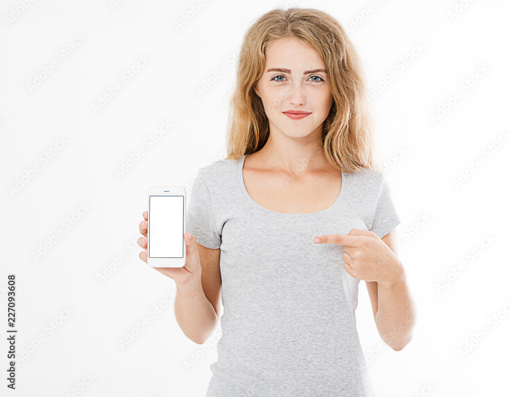 Portrait of smiling attractive, pretty, woman, girl in tshirt hold cellphone, blank screen mobilephone pointing isolated on white background, copy space. Portrait of smiling attractive, pretty, woman, girl in tshirt hold cellphone, blank screen mobilephone pointing isolated on white background, copy space.