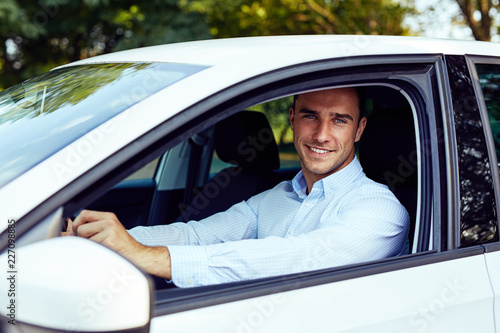 Smiling man sitting in his car, young driver