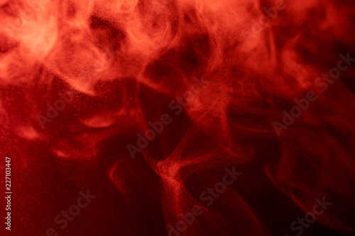 Red cloud of smoke of black isolated background. Background from the smoke of vape