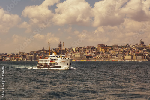 Muslim architecture and water transport in Turkey - touristic landmarks from sea voyage on Bosphorus. Cityscape of Istanbul at sunset - old mosque and turkish steamboats, view on Golden Horn.