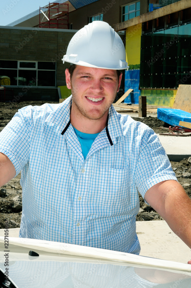 Fototapeta premium Young Male Construction Worker Wearing White Hard Hat