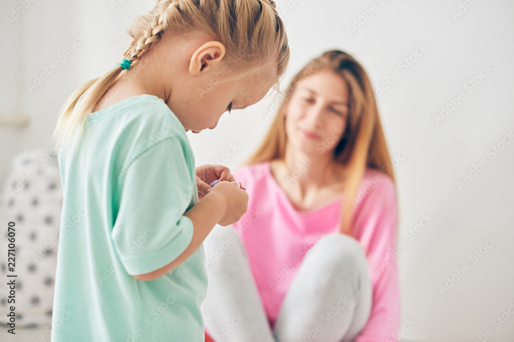 Young mother and her daughter playing in the bedroom Young mother and her daughter playing in the bedroom