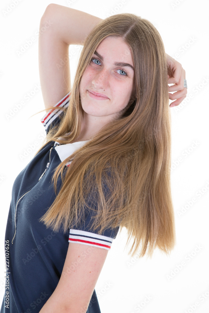 Woman in blue shirt smiles holding the back of head on white background Woman in blue shirt smiles holding the back of head on white background