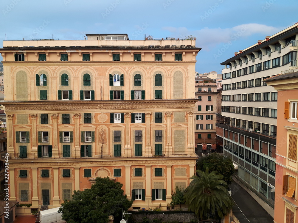 An amazing caption of the city of Genoa in the afternoon with an amazing sky and clouds and some street lights in autumn