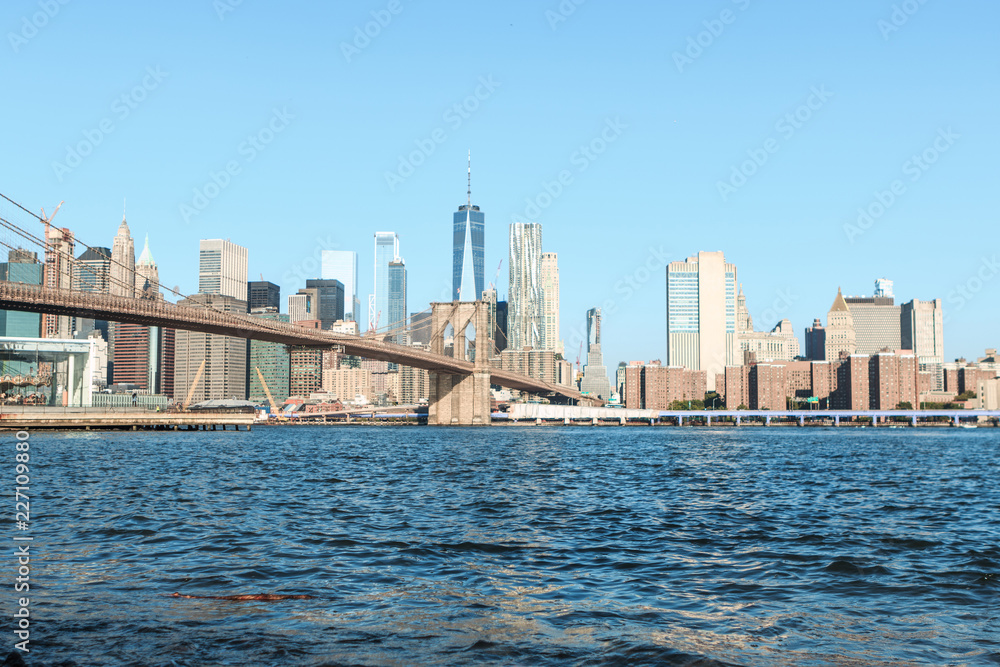 View of Brooklyn Bridge and Manhattan skyline at the early morning sun light - New York City downtown