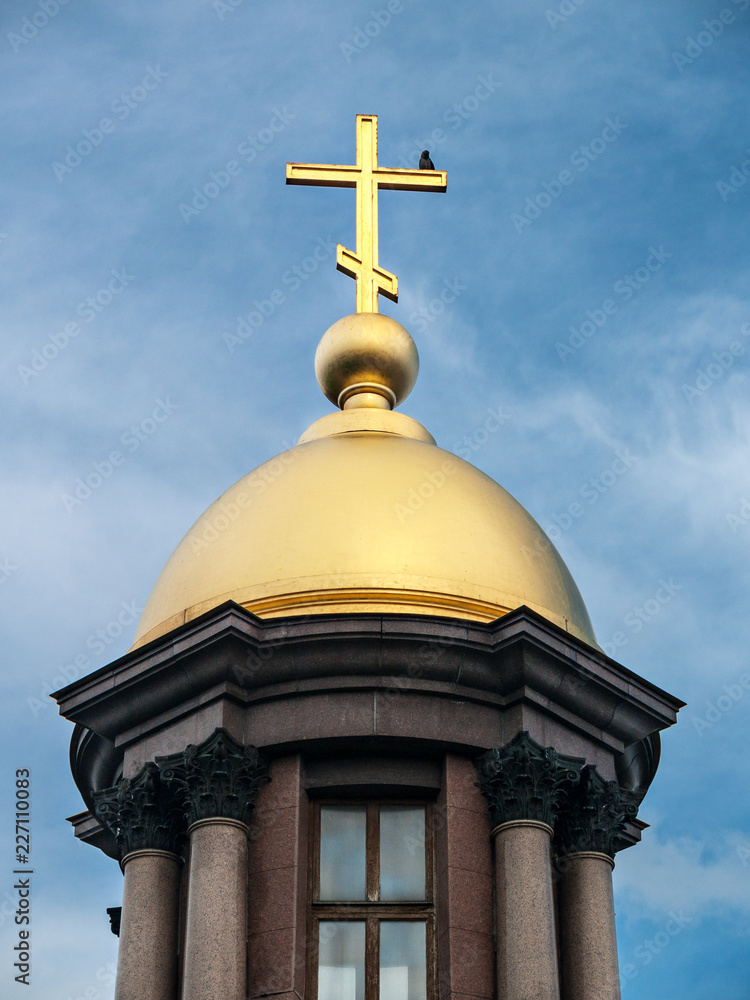 Golden dome of the chapel with a bird at the top of the cross
