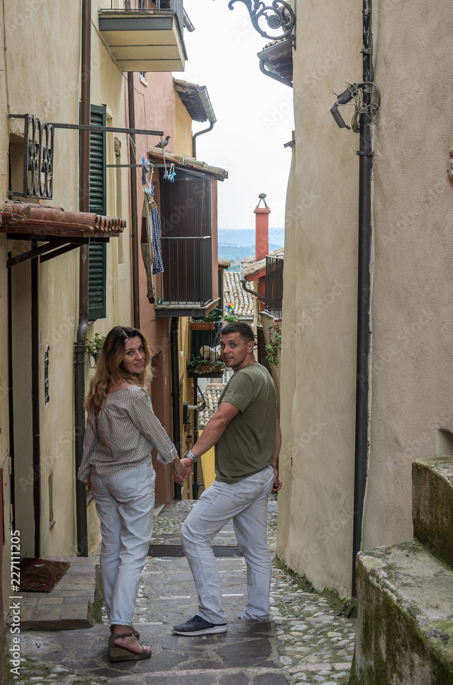Young couple in love are walking the old streets of a European city