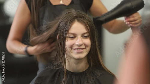 Young woman at the hair salon getting a haircut by female hairdresser