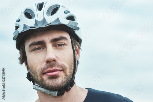 Attractive young man standing outdoors with protection helmet. Close up © Friends Stock