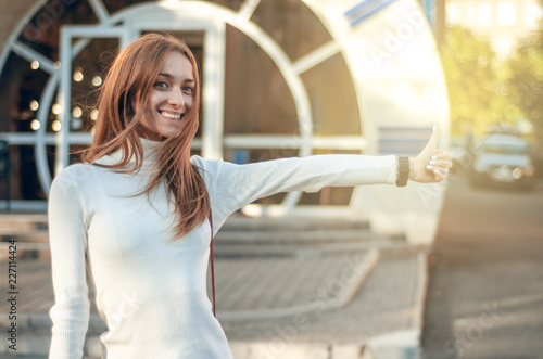 Beautiful woman catches a taxi car transport road city street