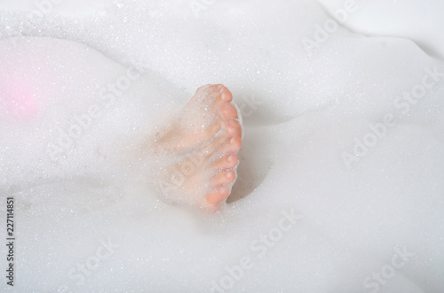 Beautiful woman in bath foam beauty health legs fingers care body water