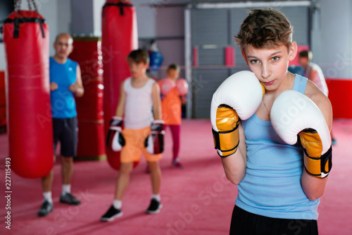 Portrait of boy boxer wearing gloves at boxing hall