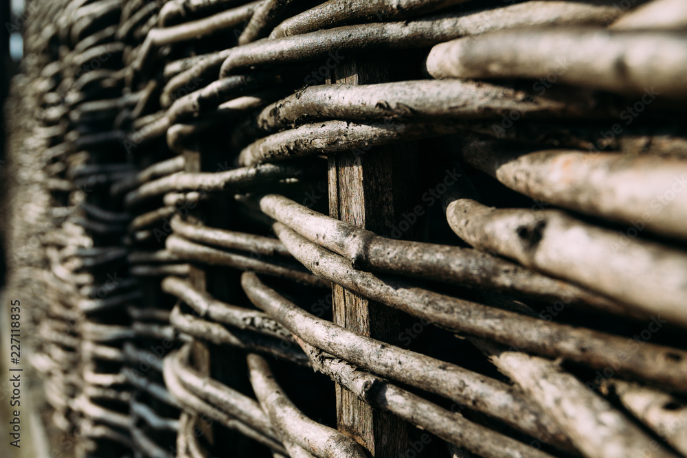 Wooden fence, assembled from flexible brown branches Wooden fence, assembled from flexible brown branches