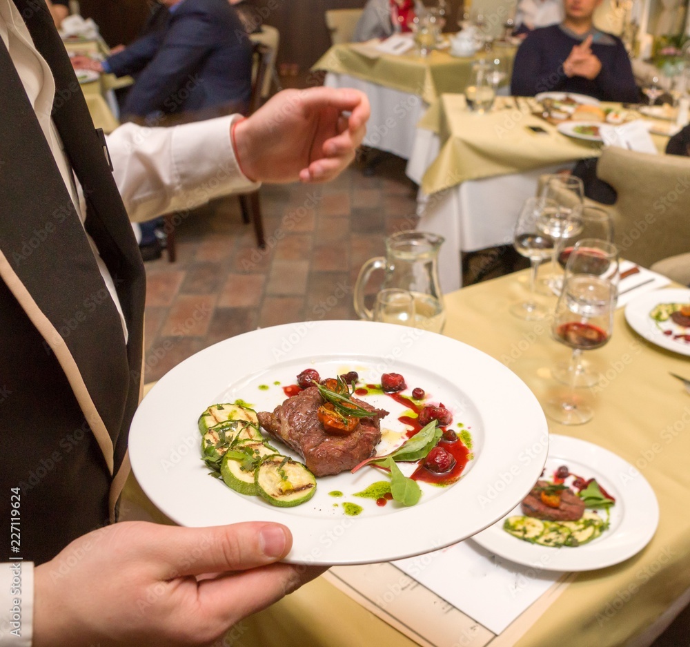 Waiter with steak on the plate Waiter with steak on the plate