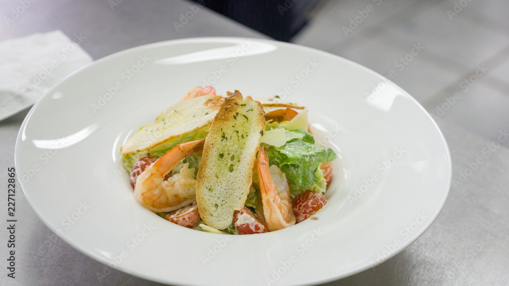 Caesar salad with shrimps on a plate before serving Caesar salad with shrimps on a plate before serving