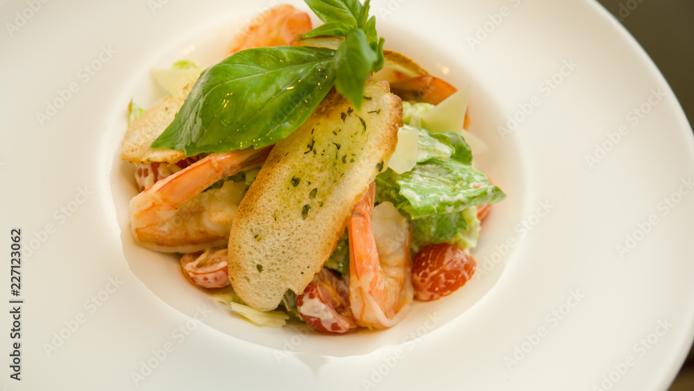 Caesar salad with shrimps on a plate before serving Caesar salad with shrimps on a plate before serving