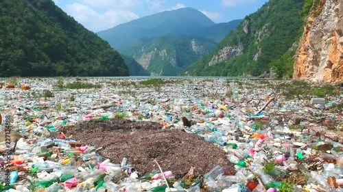 Plastic bottles in a polluted river water. Aerial view, drone view