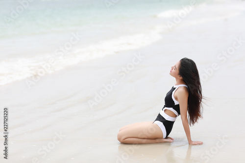 Portrait of pretty beautiful sport fashion woman in  bikini posing in summer near the sea and blue sky in sunshine with gorgeous smile in happy mood on tropic island on vacation