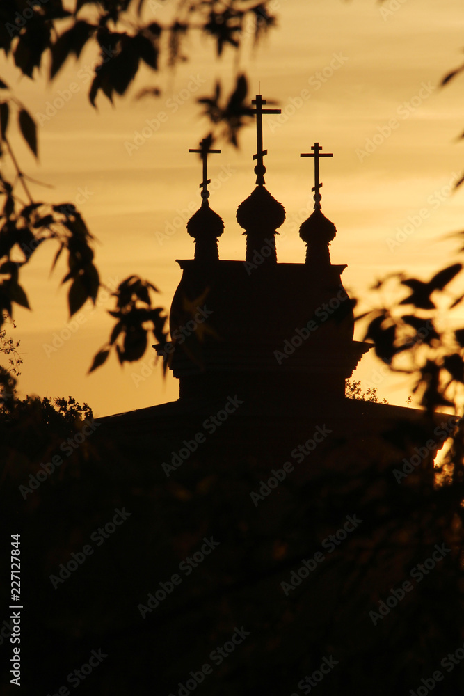 The silhouette of cupolas of Wooden Saint George Church in Kolomenskoe against bright sunset sky
