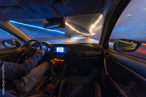 Driving in the night landscape, hands on the wheel. Raindrops.