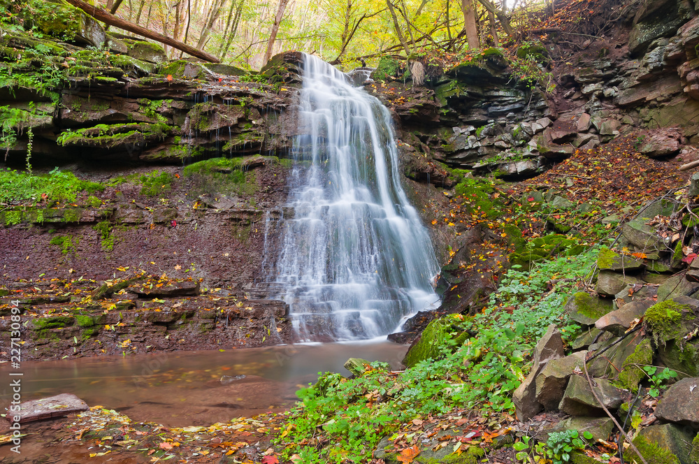Obraz premium Beautiful waterfall on a mountain stream in the woods
