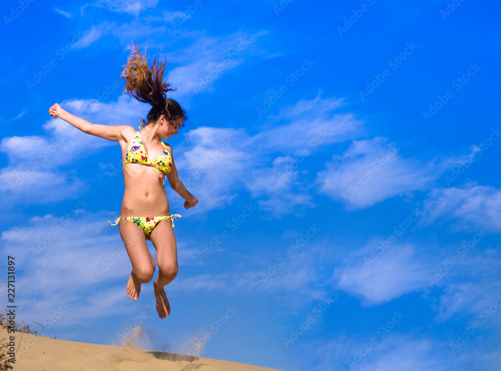 Attractive Girl in Bikini Jumping on the Beach Having Fun, Summer vacation holiday Lifestyle. Happy women jumping freedom on sand. Attractive Girl in Bikini Jumping on the Beach Having Fun, Summer vacation holiday Lifestyle. Happy women jumping freedom on sand.