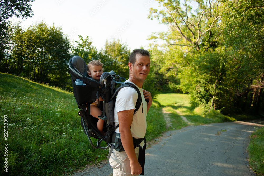 Father on a walk with kik in child carrier backpack Father on a walk with kik in child carrier backpack
