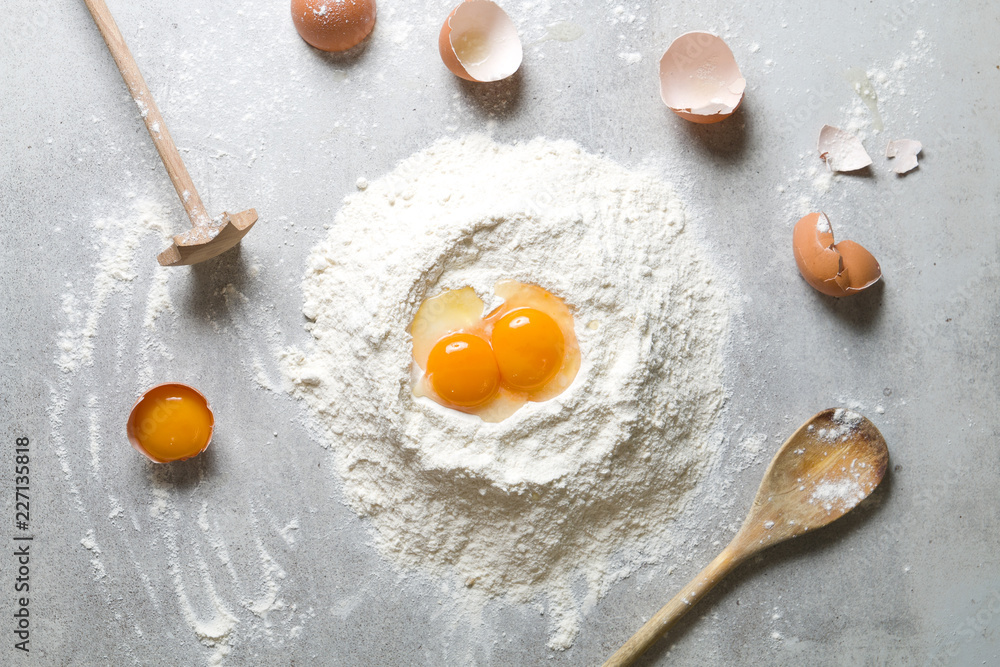 Process of baking flour and eggs on a gray table.View from above. Process of baking flour and eggs on a gray table.View from above.