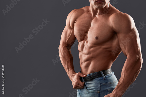 Bodybuilder man with perfect abs, shoulders,biceps, triceps and chest, personal fitness trainer. Unrecognizable Strong bodybuilder.