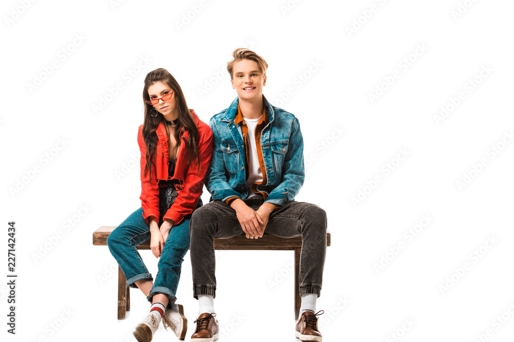 attractive hipster girl in eyeglasses and her boyfriend sitting on bench isolated on white