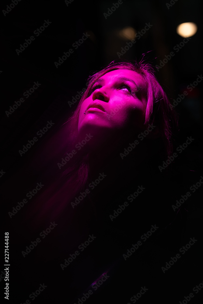 Portrait of girl with reflection of herself looking up on pink lights Portrait of girl with reflection of herself looking up on pink lights